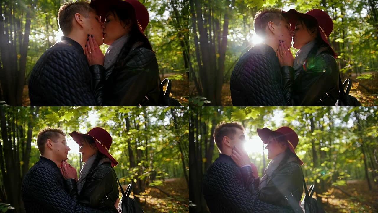 恋爱中的情侣在日落时在秋天的公园里接吻，慢动作