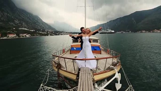 婚礼情侣牵手在布德瓦黑山海上航行的船尾