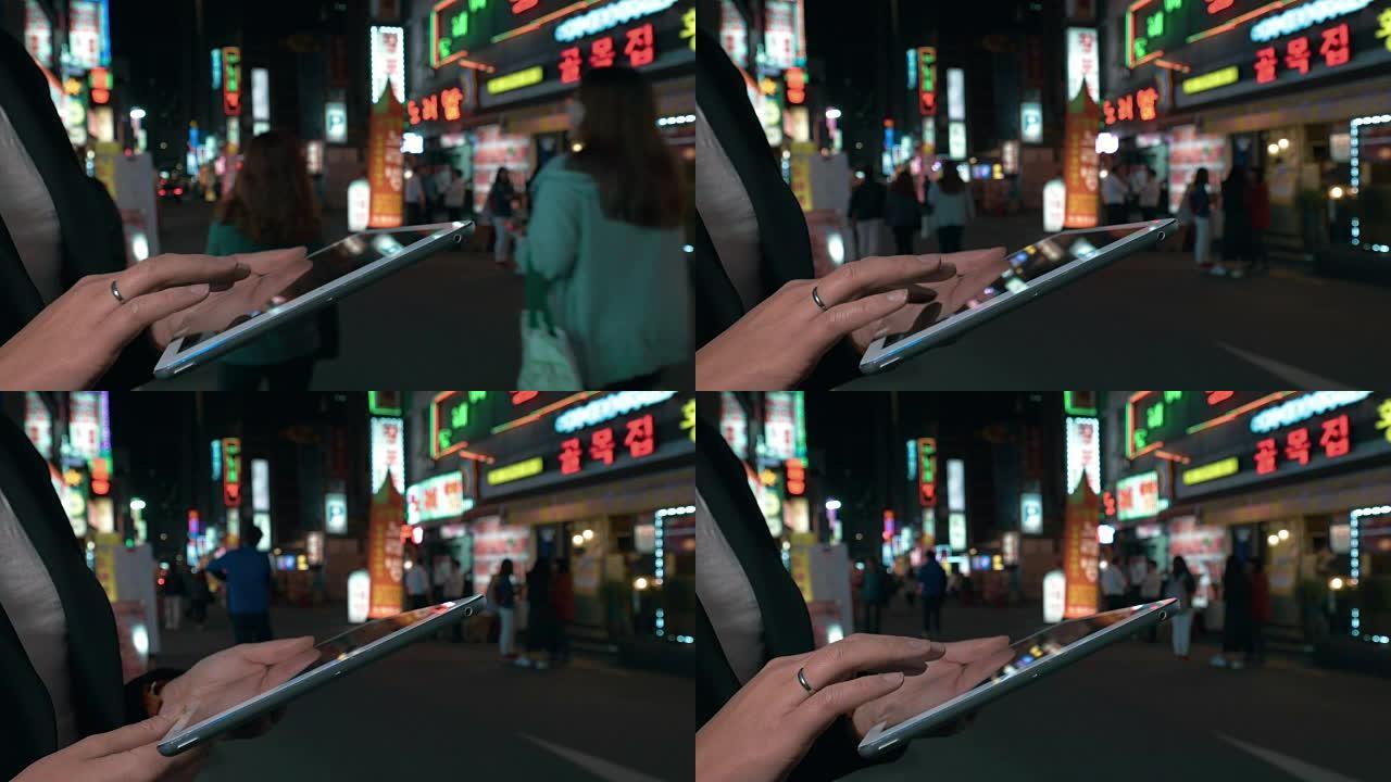 女人在夜间在韩国首尔的pad上浏览网络