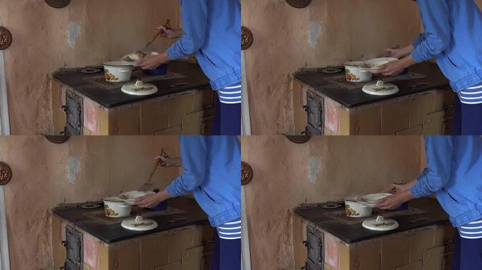 丫头女人在炉子上从沸腾的锅里拿煮熟的饺子。全高清