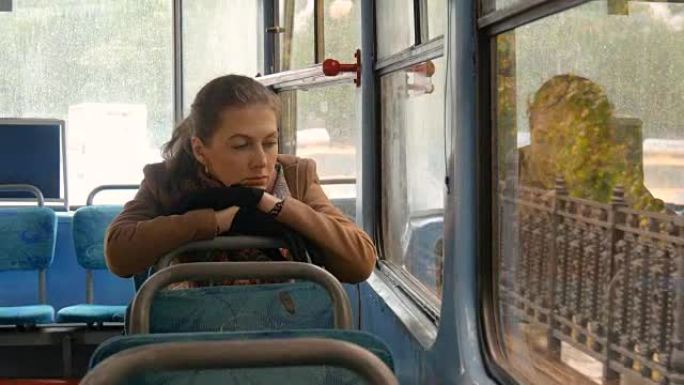 一个有着悲伤眼神的美丽女孩坐在电车上。慢动作