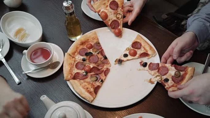 手拿披萨切俯视图，特写镜头。在咖啡馆里，交流和朋友