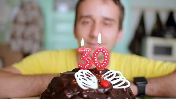 男人用蝴蝶翅膀的巧克力蛋糕吹灭了30年的蜡烛。这个人今天过生日