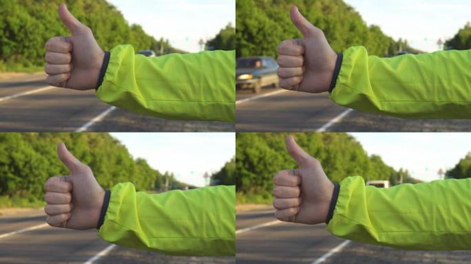 搭便车的年轻成年男子在州际公路上竖起大拇指