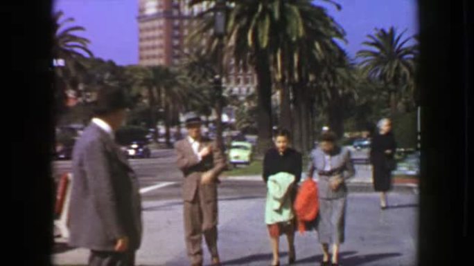 1957: 家庭行走阳光明媚的棕榈树宽街道比佛利山庄的新街。