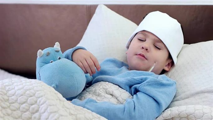 生病的孩子睡觉，带电子温度计的孩子，躺在床上，生病时高温，生病，喉咙痛