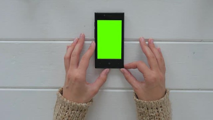 女人看着绿色屏幕的智能手机