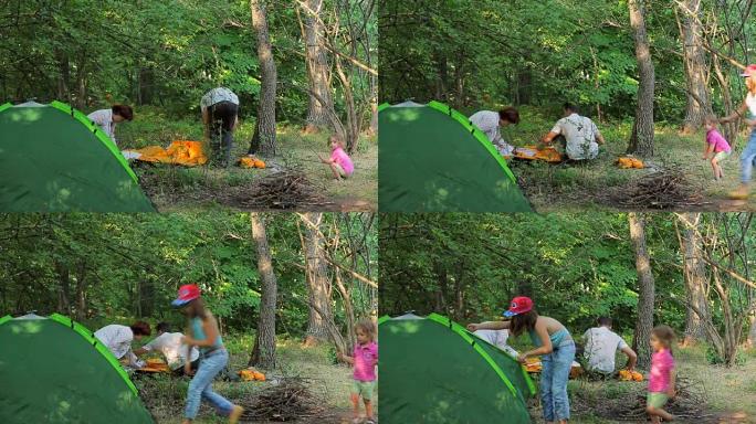 家庭在绿色森林中搭建帐篷