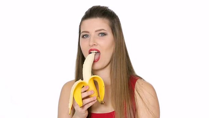 美丽的女孩在白色背景上吃香蕉