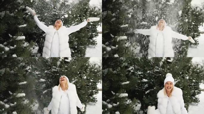 迷人的金发女郎在冬季风景的背景下与雪玩耍