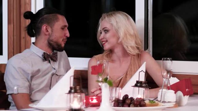 浪漫的约会，在餐厅里相爱的情侣，在咖啡馆里浪漫的气氛中给恋人、男孩和女孩的夜晚，温柔的吻，美丽的餐桌
