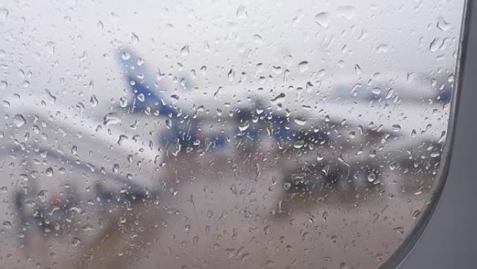 从机场降落时，飞机窗户上的雨滴