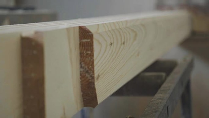 板条从机器下面出来。木制锯末