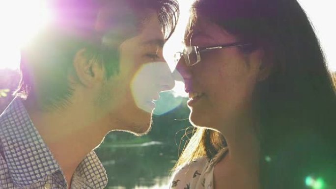 一对情侣在日落时接吻的特写镜头
