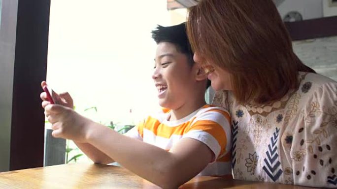 幸福的亚洲家庭母子被智能手机自拍