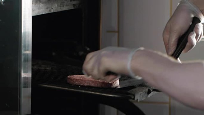 燃烧的烧烤和牛肉汉堡，在现代咖啡馆的新鲜肉类中关闭厨师烹饪，翻过洪堡