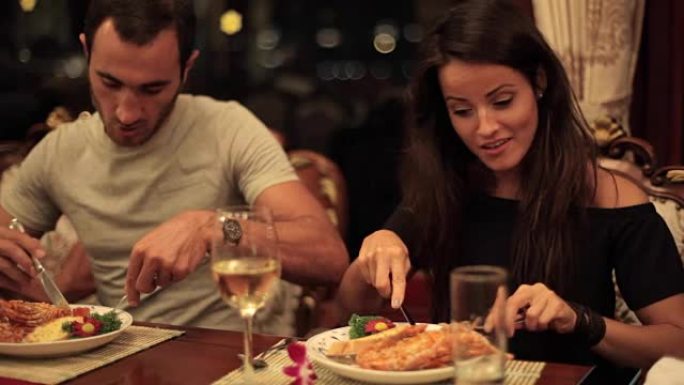 年轻夫妇在船上的餐厅在浪漫的气氛中用餐