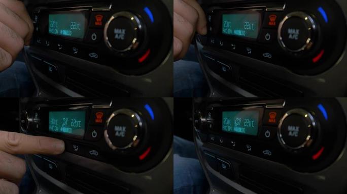 调节车内空调按钮的手特写。使用汽车空调系统的人