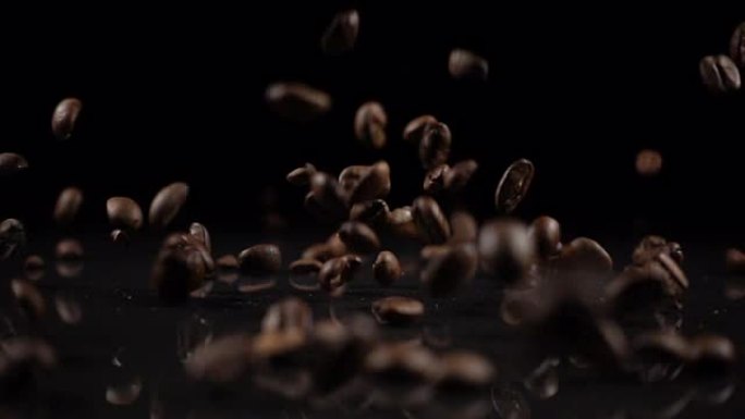 咖啡豆落在坚实的黑色表面上