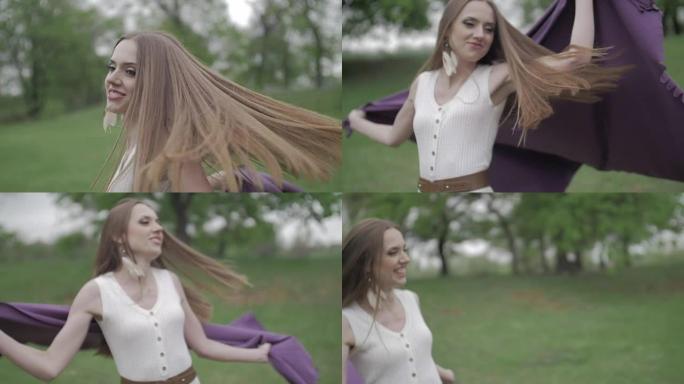 快乐的年轻女人在户外玩。身穿白裙的美女手拿紫色格子，在森林里纺纱欢笑。中间拍摄