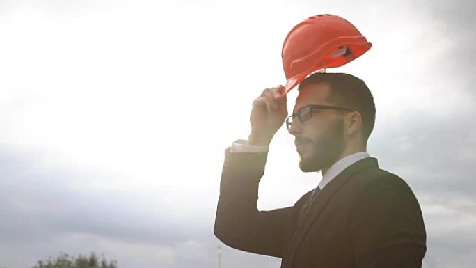 工作中的专业人员，在建筑工地戴着安全帽的快乐而自信的建筑师肖像