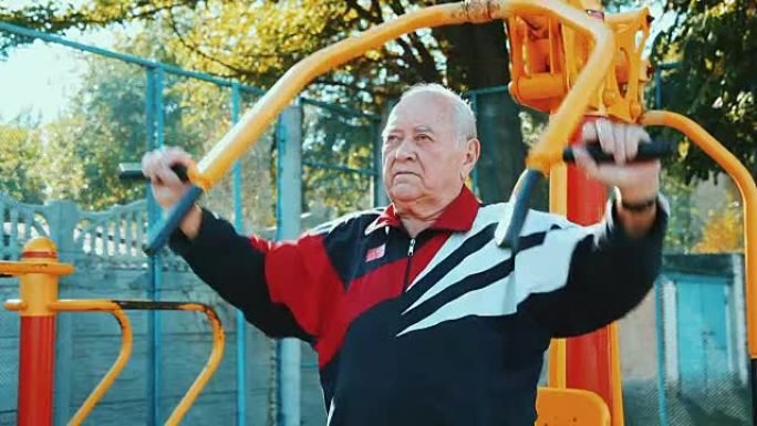 老人在公共户外健身房用健身器材锻炼。