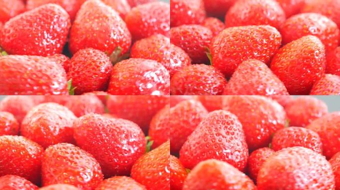新鲜，成熟，多汁的草莓旋转。红色草莓顺时针旋转。带有水滴的开胃浆果在托盘上旋转