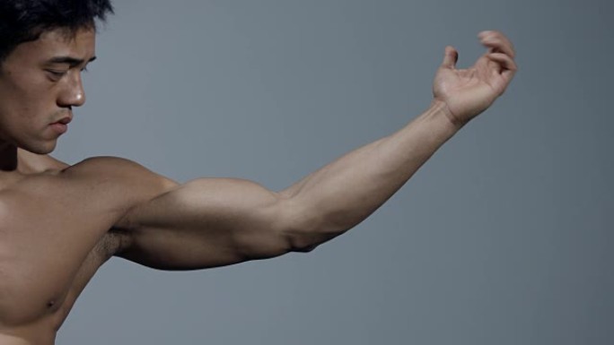 男性健身模型伸出手臂，弯曲二头肌