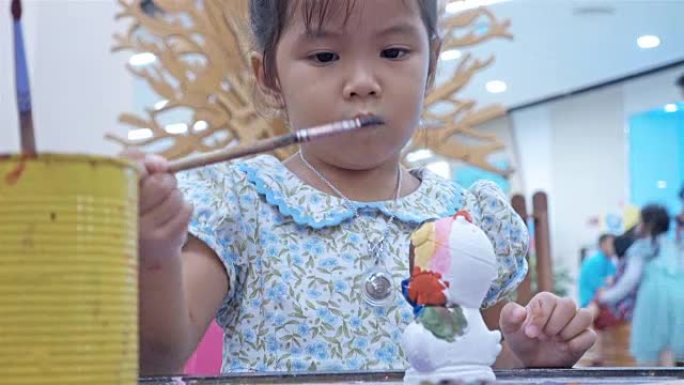 小女孩学习绘画的特写肖像用儿童手到白色石膏娃娃玩具