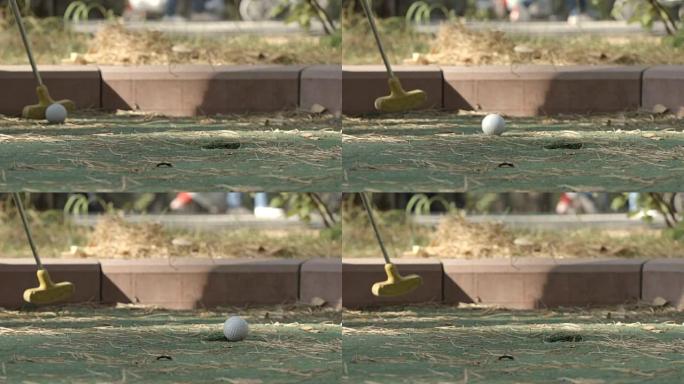 慢动作: 小球员将高尔夫球打向洞