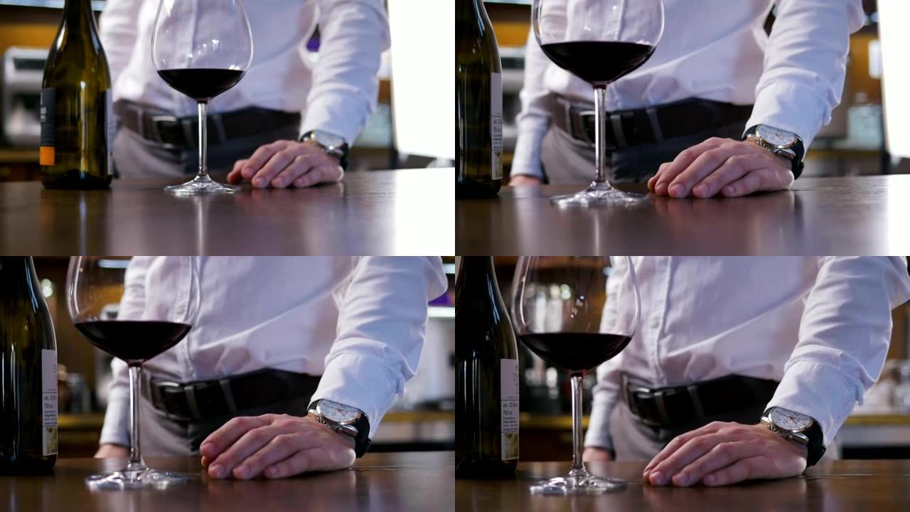 用一杯葡萄酒关闭男人的手的镜头