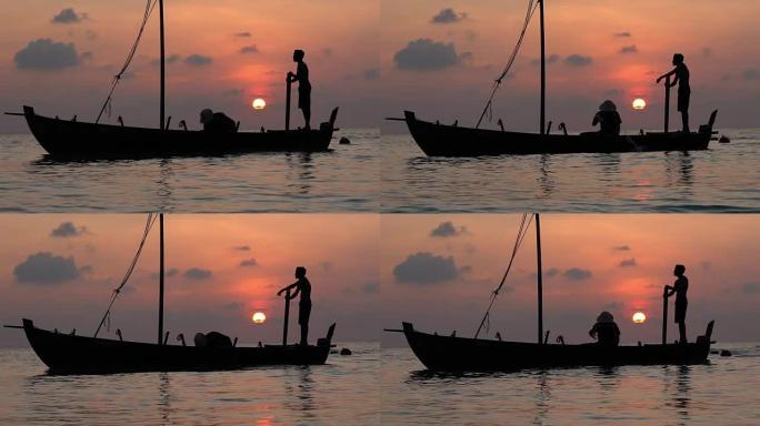 在印度洋日落的艰难一天结束时，两名渔民从一艘旧木船上舀了水。慢动作。