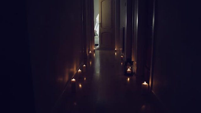 4k惊悚片在长长的大厅里用蜡烛拍摄，一个白色的幽灵打开了门