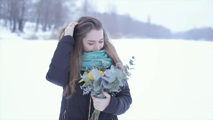 在冰冻的湖上捧着一束鲜花的女孩。慢动作