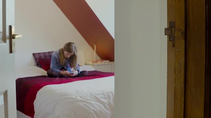 年轻女孩，头发躺在床上，使用智能手机短信。