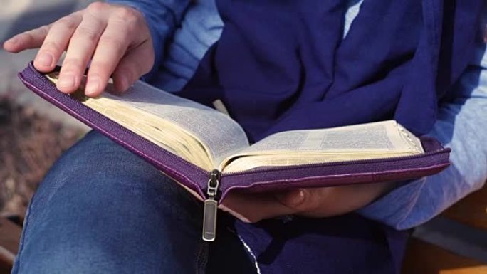 女人的手在外面读圣经时的特写