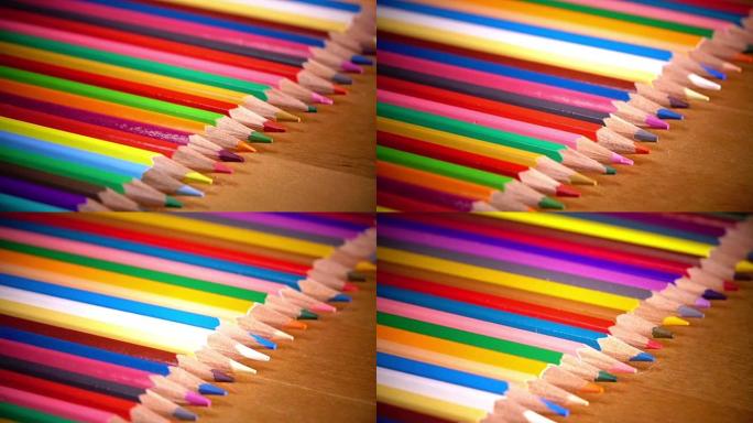 鲜艳的彩色铅笔在木制表面上排成一排