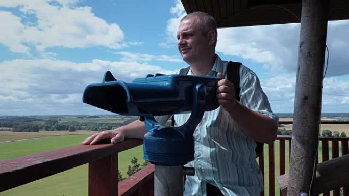 观景塔上使用双筒望远镜的游客