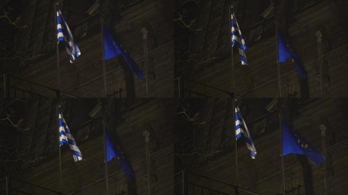 两面旗子晚上在旗杆上飘扬