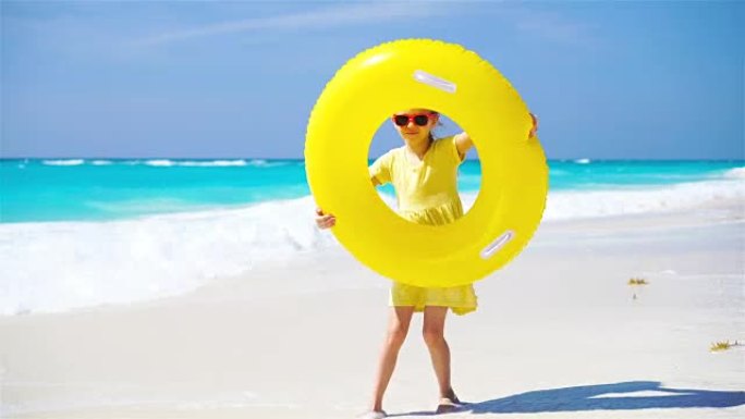 海滩度假带充气橡胶圈的小女孩
