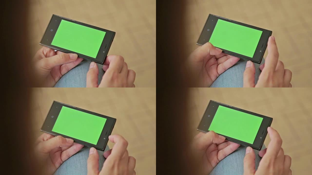 手握绿屏显示的漂亮女人智能手机
