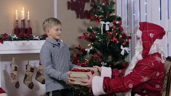 圣诞老人竖起大拇指给小男孩送礼物，男孩摇了摇盒子
