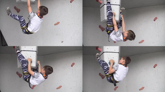 小家伙在运动健身房锻炼攀岩。在攀岩墙上训练登山者