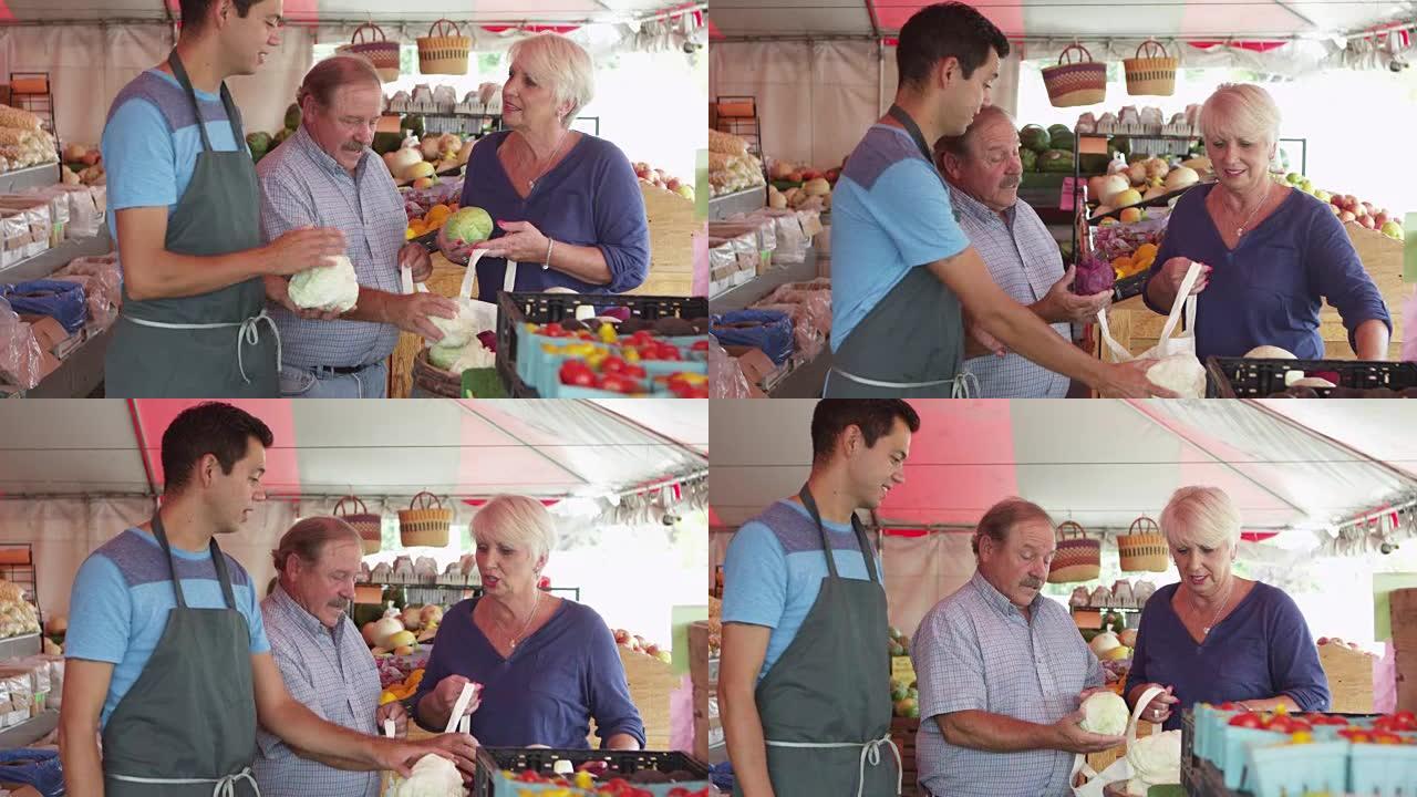 杂货商帮助老年夫妇采摘新鲜蔬菜