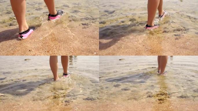 女孩穿着胶鞋进入大海，特写镜头。