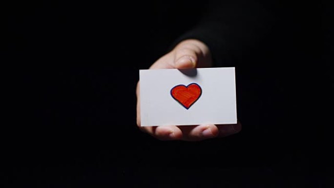 一只手展示了一张浪漫的卡片，上面写着 “我爱它”。概念: 爱，帮助他人，喜欢，激情，分享。