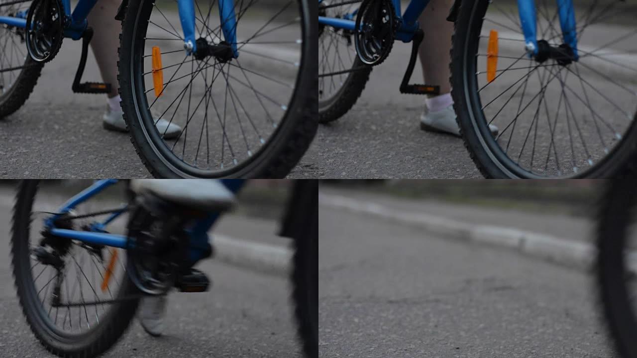 在柏油路上启动自行车的特写镜头