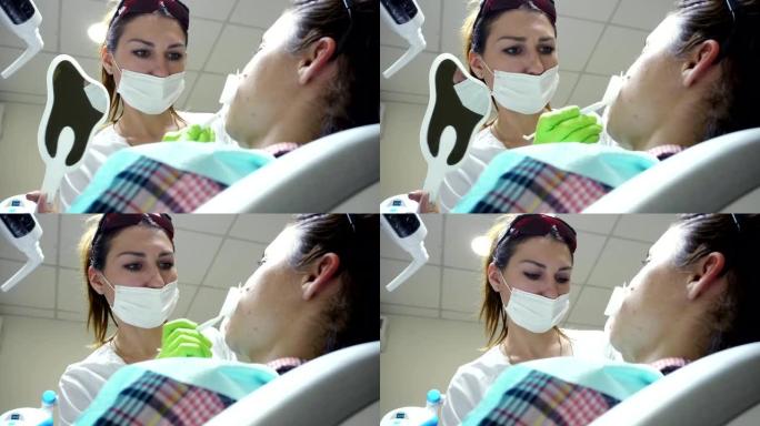 戴面具的女性口腔科医生。女医生在工作。照镜子的病人。特写视图。4k拍摄