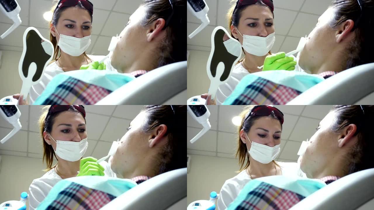 戴面具的女性口腔科医生。女医生在工作。照镜子的病人。特写视图。4k拍摄