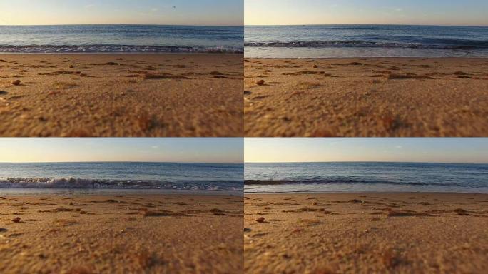 夏季，日出时在带有沙质斜坡的野生海滩上冲浪